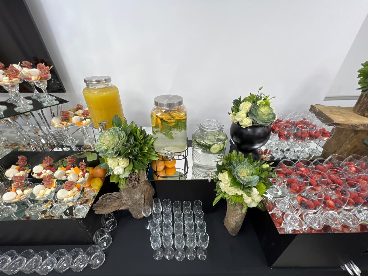 Mesa de catering corporativo con bebidas y alimentos